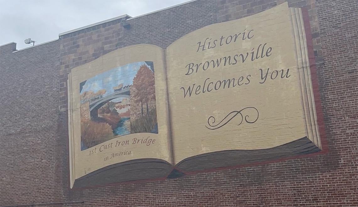 A mural of an open book that says Historic Brownsville Welcomes You